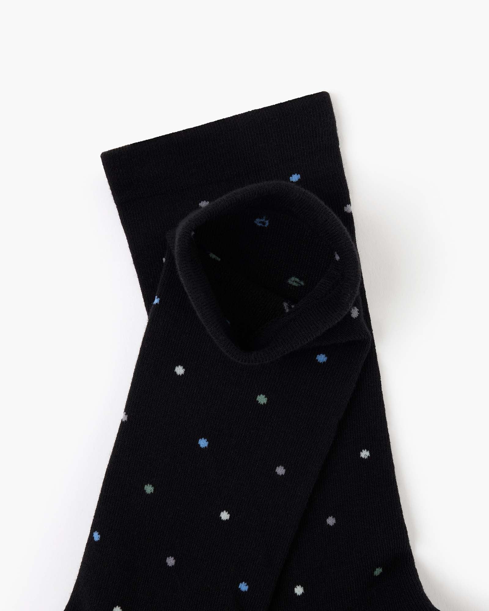 black crew sock with a pattern of small multicolored polka dots