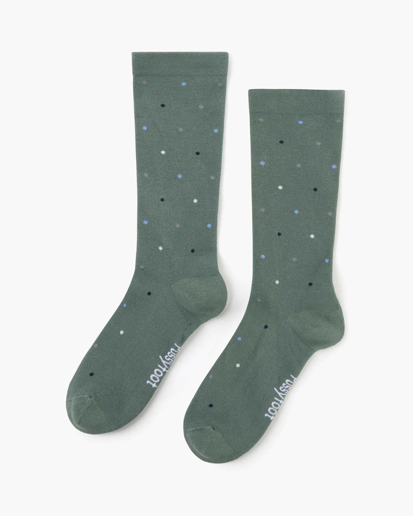 green crew sock with a scattered pattern of small polka dots in white, light blue, and black